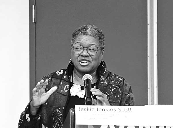 woman into microphone speaking at an event